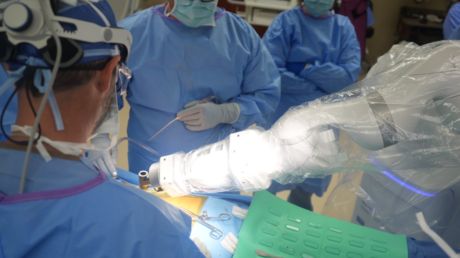 Dr. Hobbs at the operating table with the draped Stealth AXiS robotic arm positioned over the surgical field